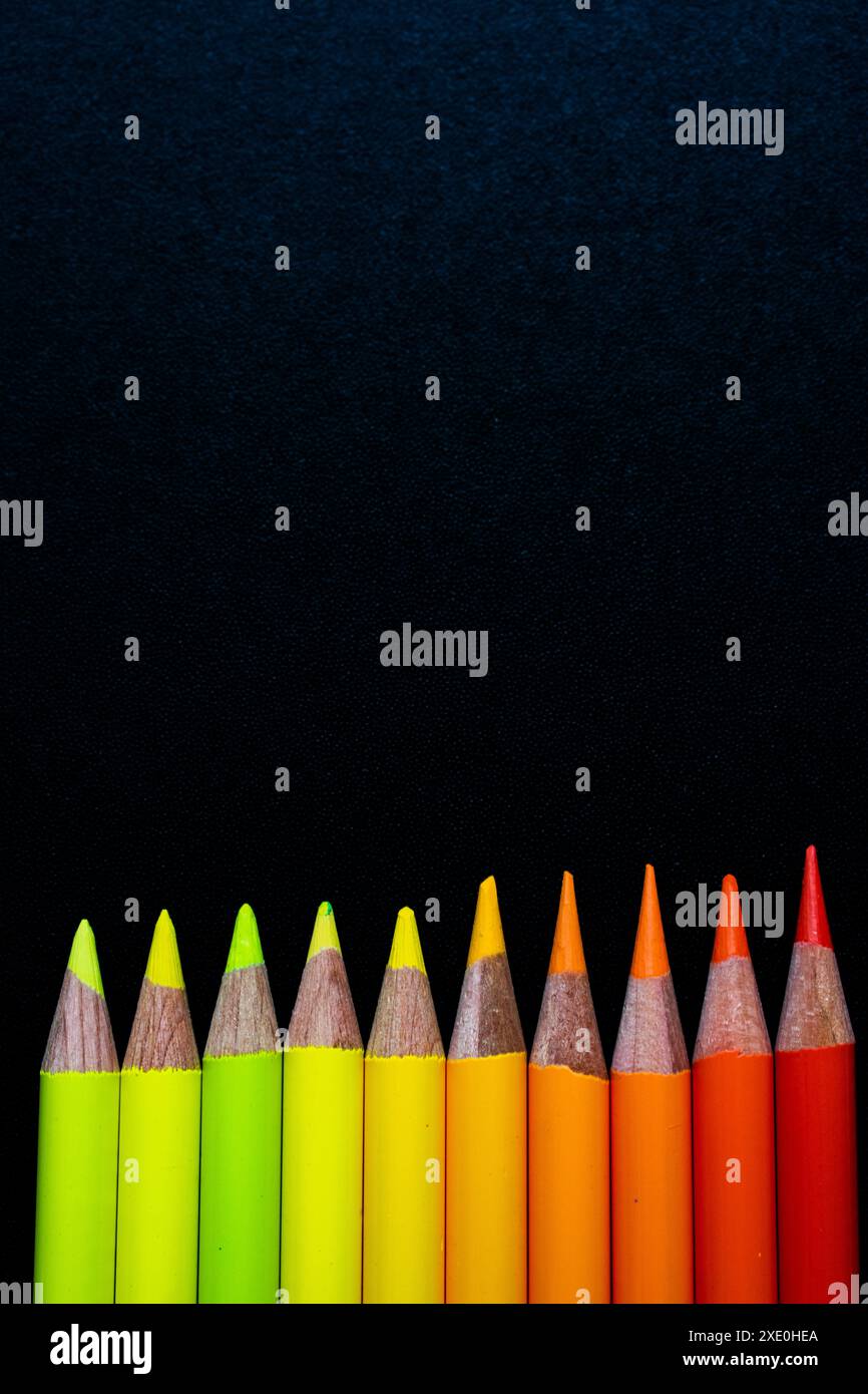 Pencils on black canvas yellow to red Stock Photo