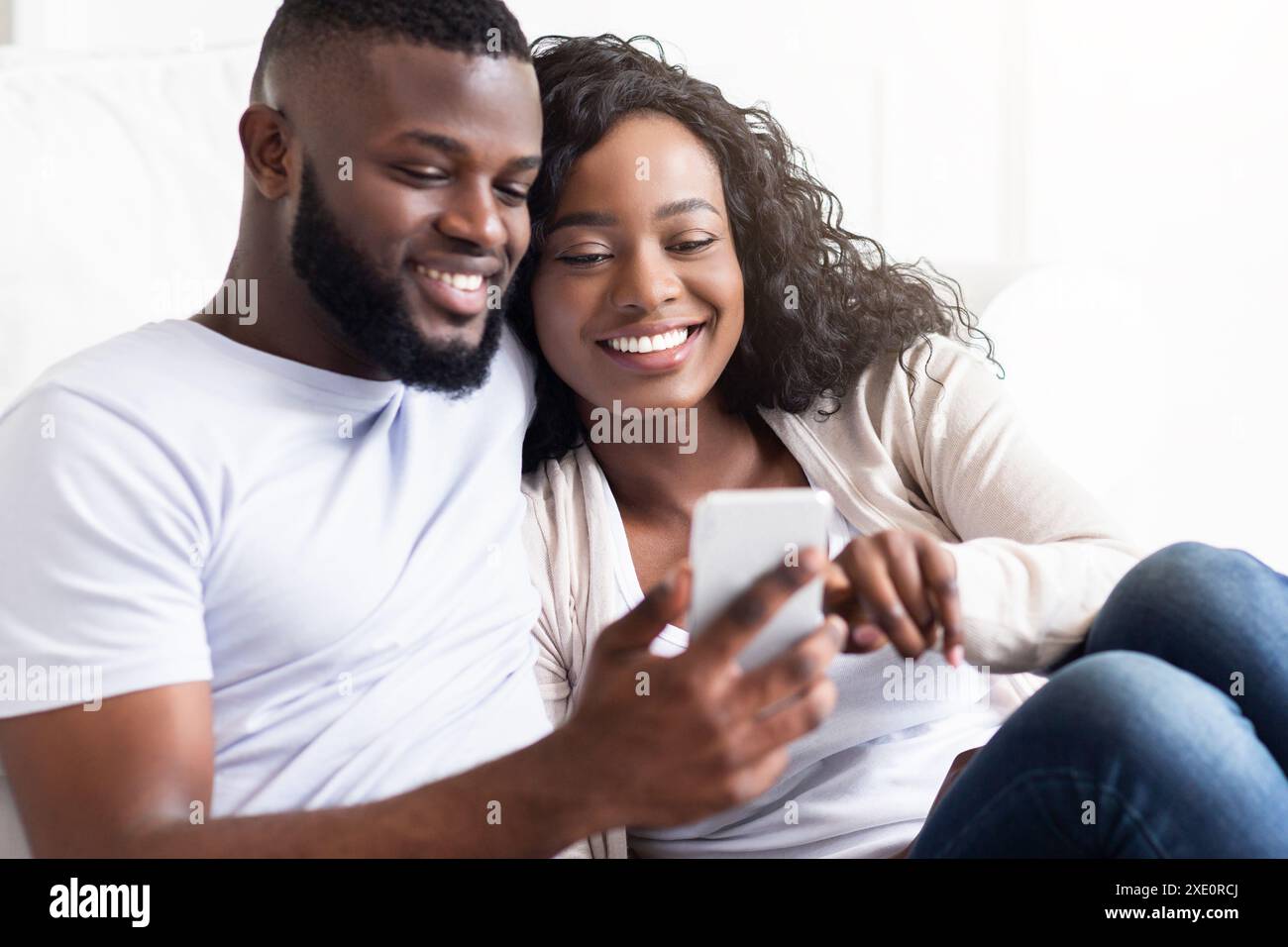 Couple Using Smartphone Together Indoors Stock Photo