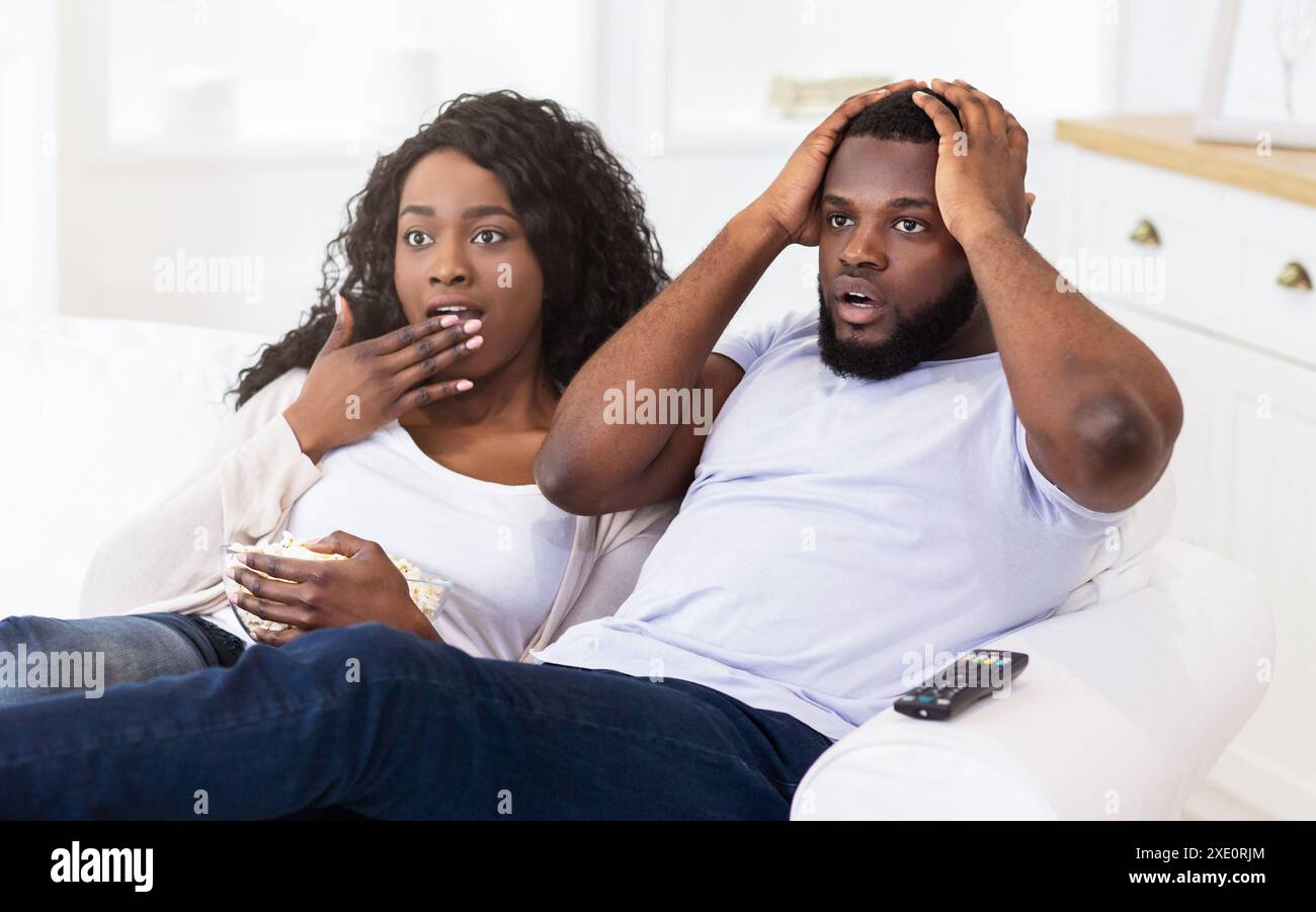 Shocked Couple Watching TV Stock Photo