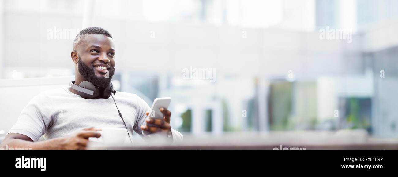 Man Using Smartphone and Drinking Coffee Outdoors Stock Photo