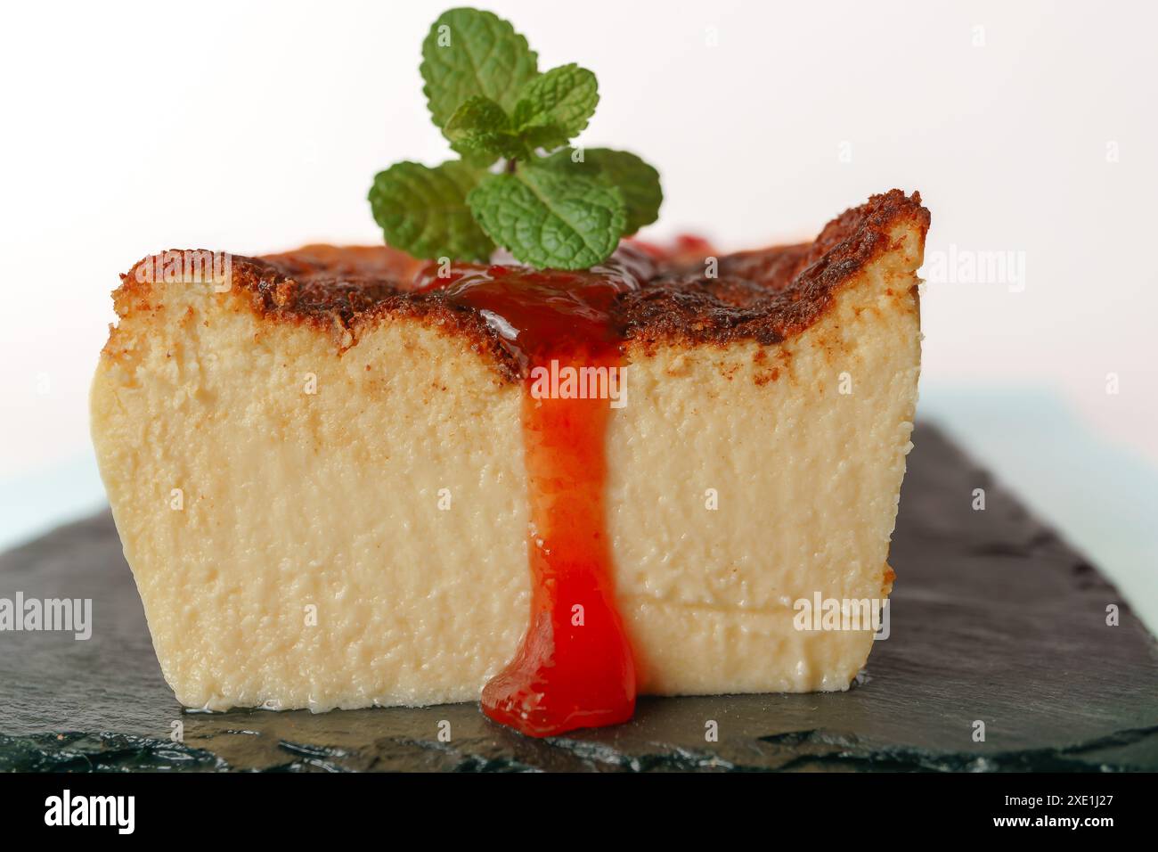 Cheesecake with strawberry jam on black board Stock Photo