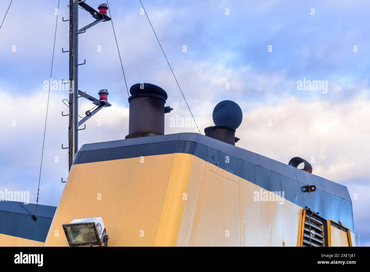 Smoke belching out from a funnel of ferry in navigation under cloudy sky at dusk Stock Photo