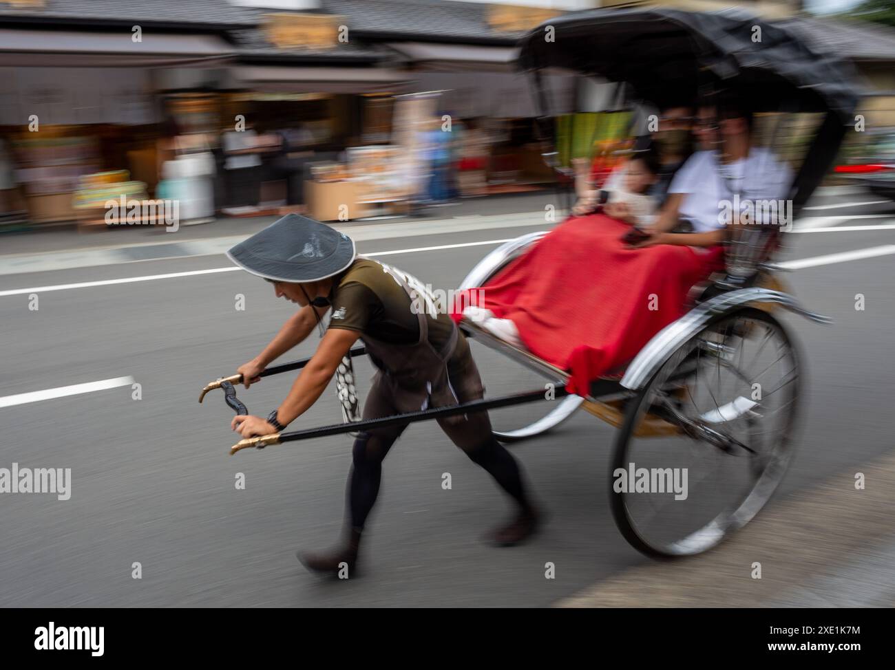 Tokyo, Japan. 25th June, 2024. A rickshaw rider pulls the Jinrikisha ...