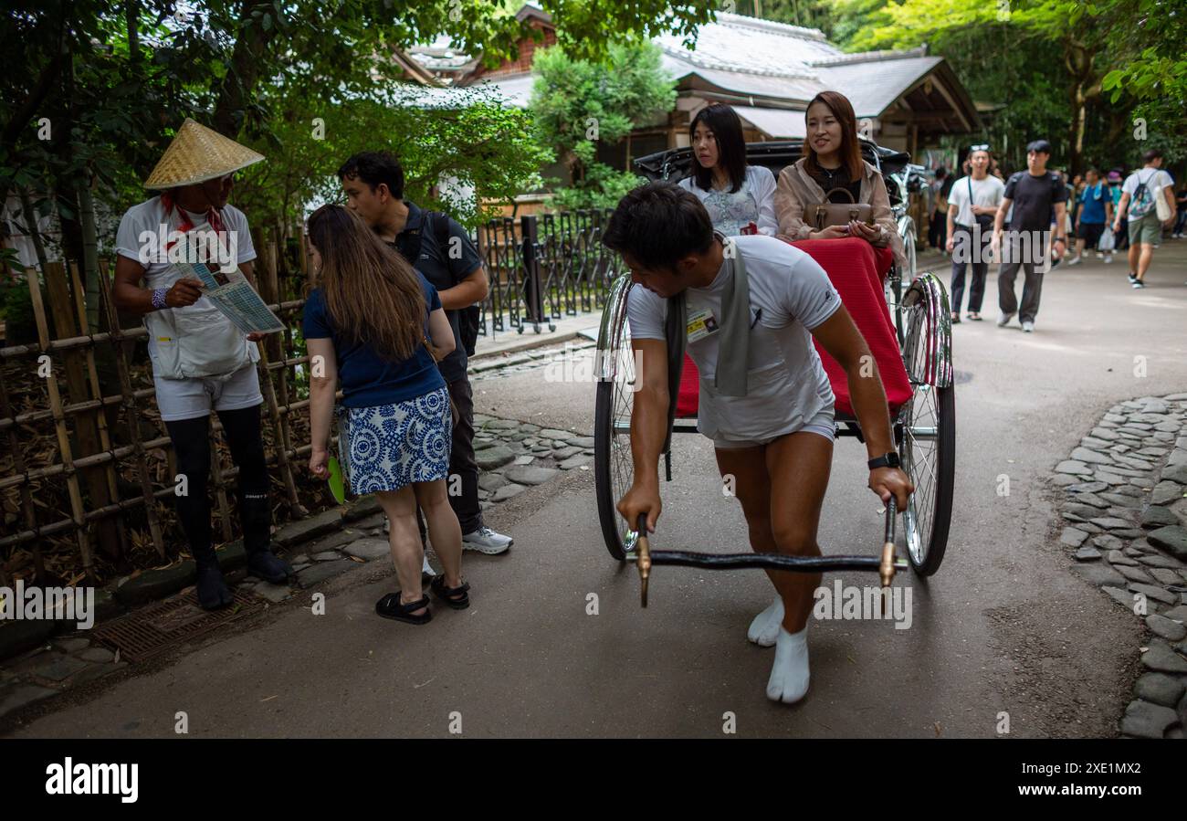 Tokyo, Japan. 25th June, 2024. A rickshaw rider pulls the Jinrikisha ...