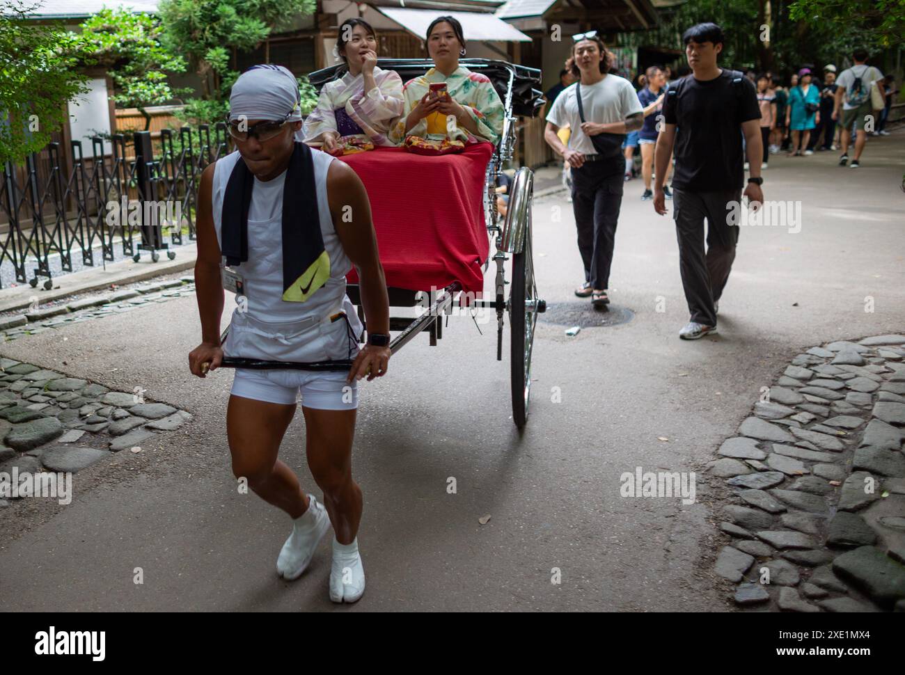 Tokyo, Japan. 25th June, 2024. A rickshaw rider pulls the Jinrikisha ...