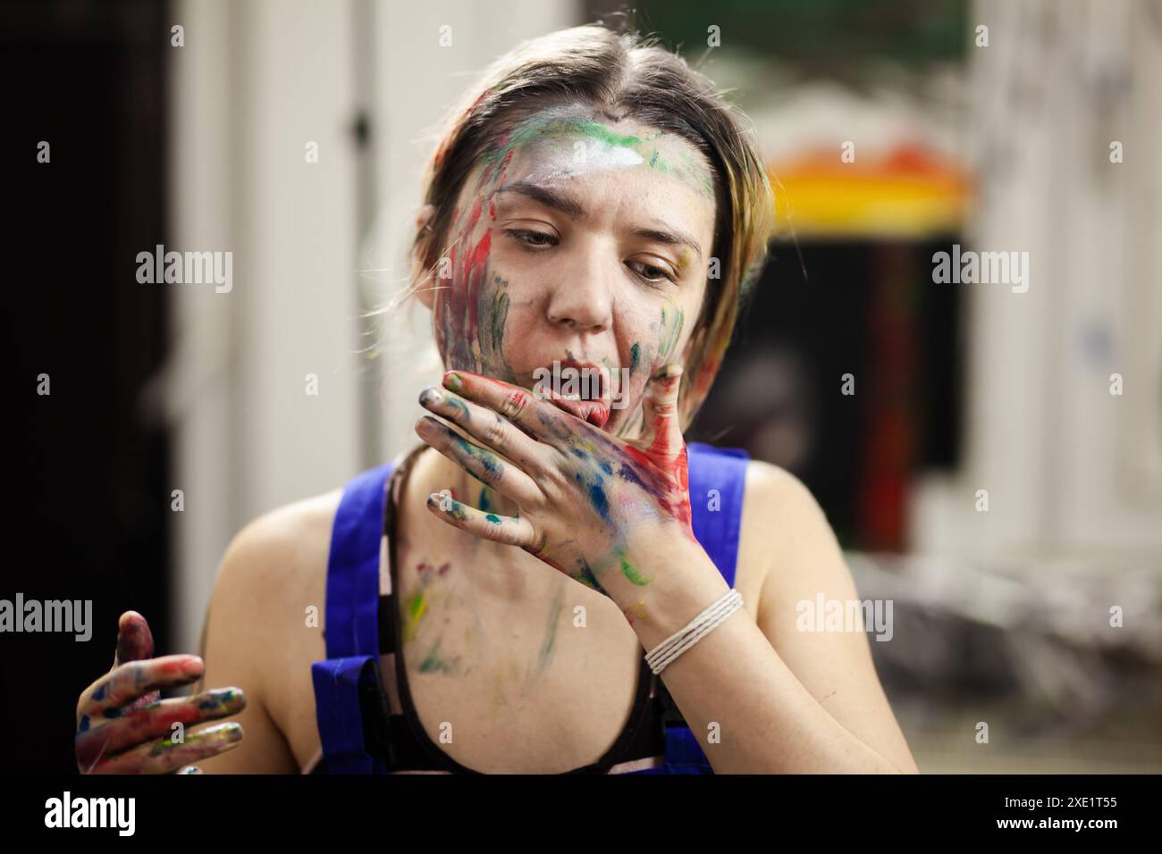 Portrait of a female artist. Girl with clumsy clorful painted face ...