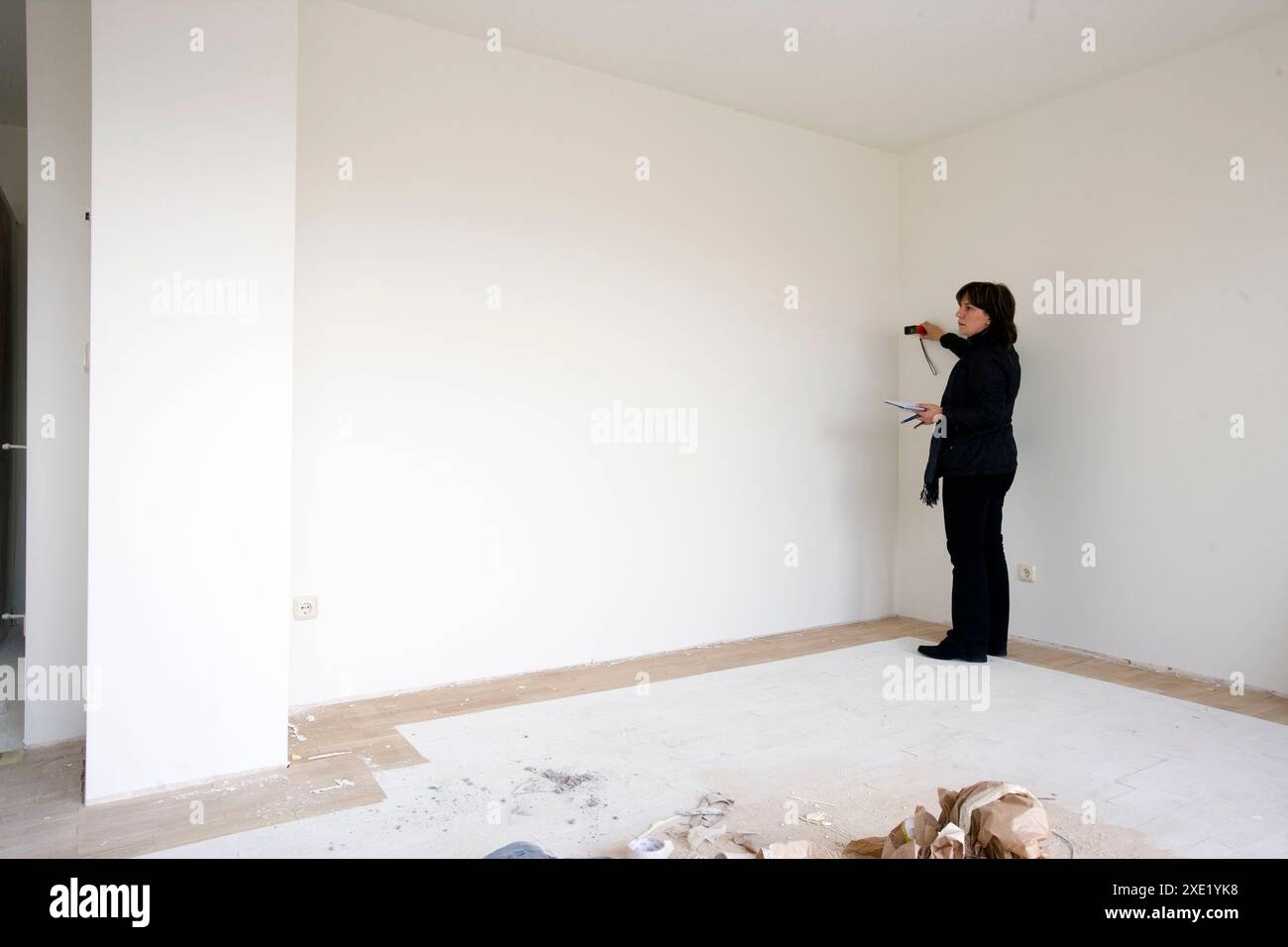 Interior decorator taking measures in empty room Stock Photo