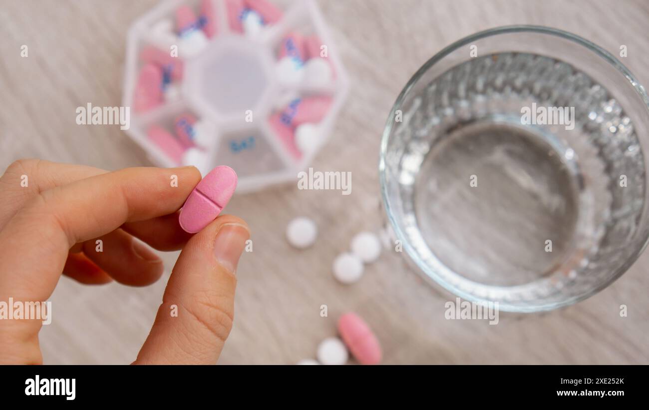 Woman sorting pills Organizer weekly shots Closeup of medical pill box with doses of tablets for daily take medicine with white Stock Photo