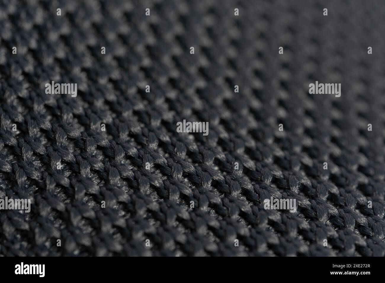Black knitted fabric as a background. Close-up. Macro Stock Photo