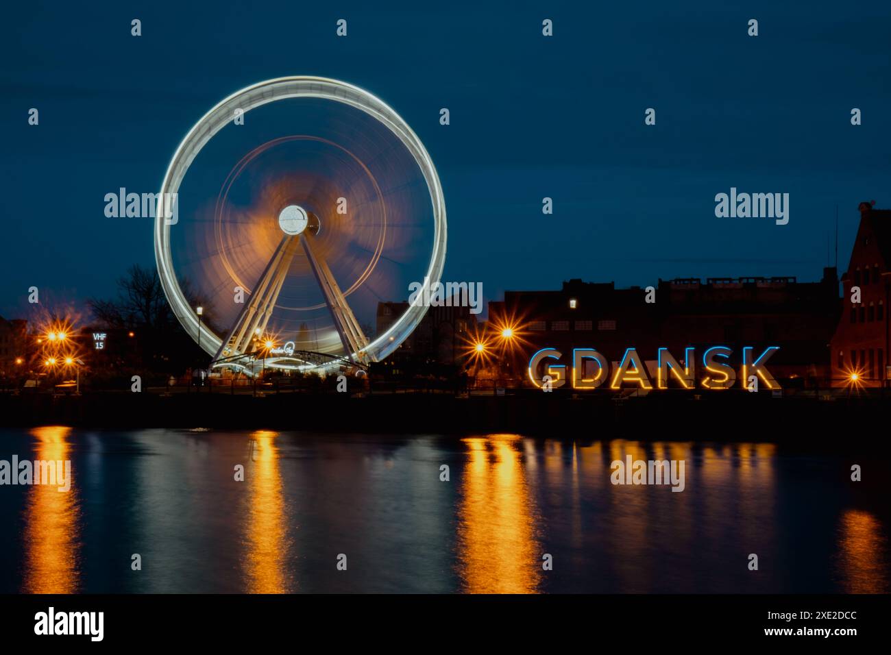 Gdansk Poland Ferris wheel in the old town of Gdansk at night evening dusk Reflection in river water Europe. Long exposure photo Stock Photo