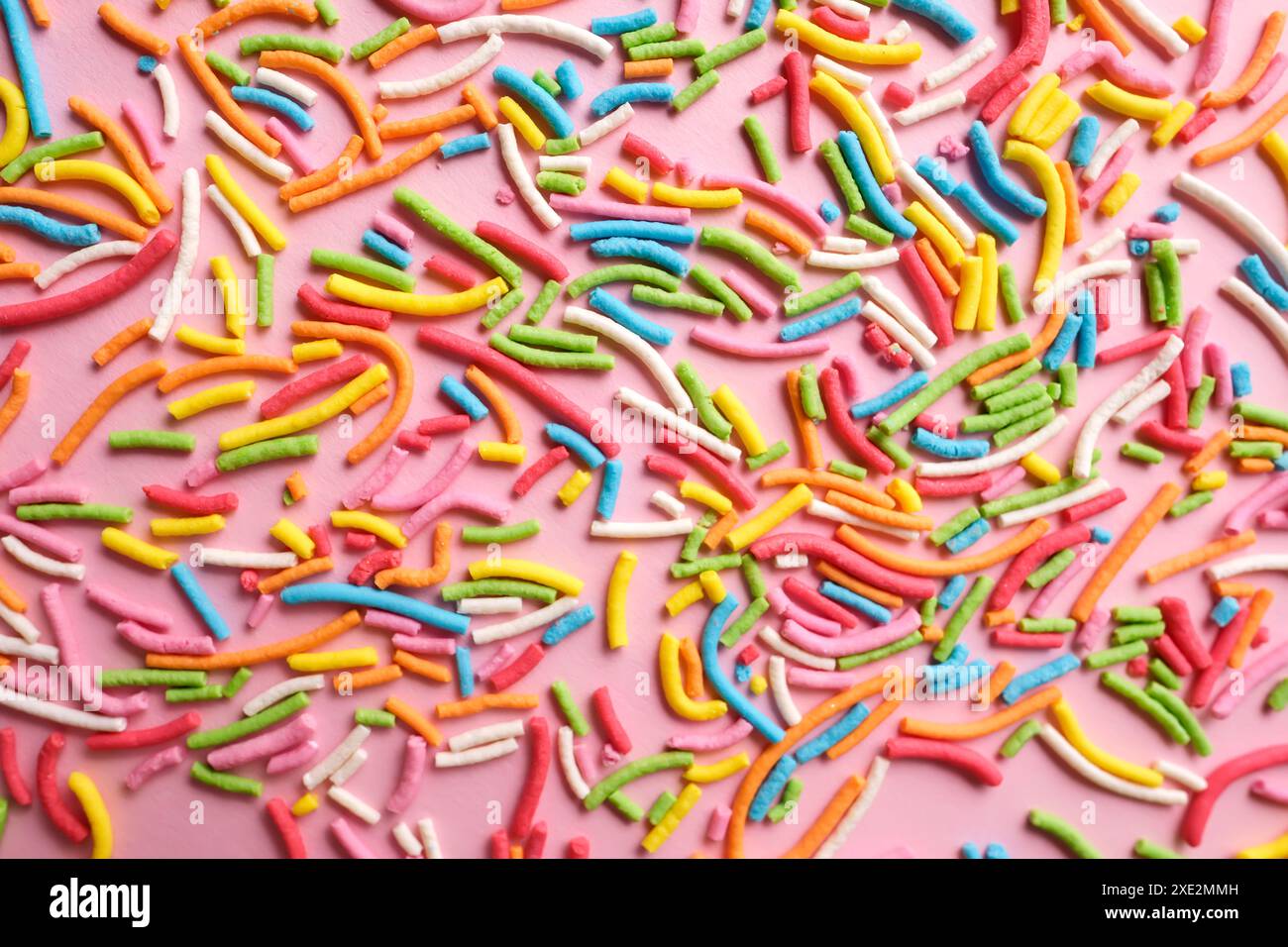 Multi-colored confectionery topping on a pink. Stock Photo