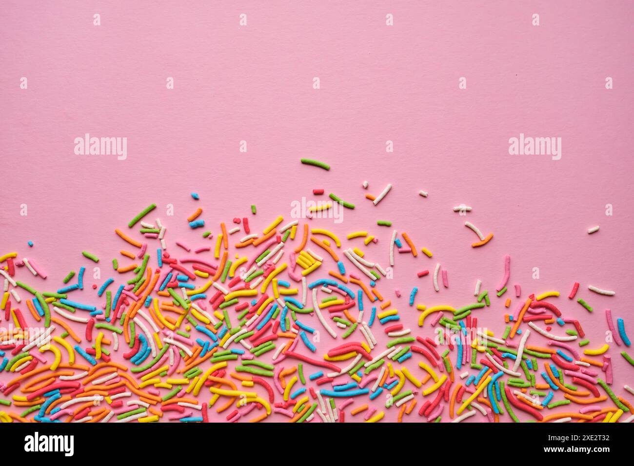 Multi-colored confectionery topping on a pink. Stock Photo