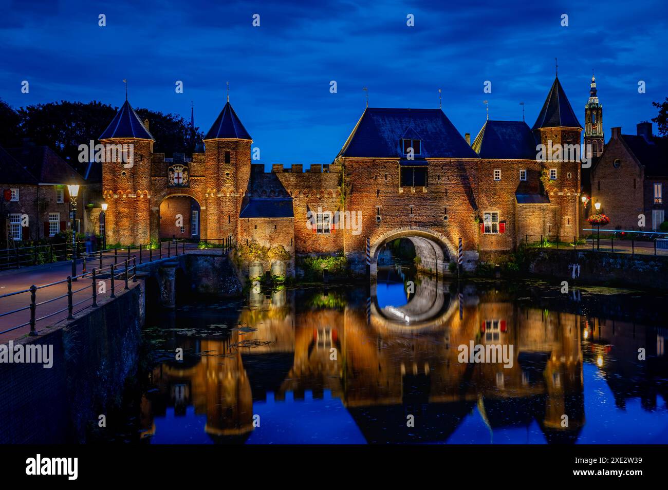 Medieval fortress city wall gate Koppelpoort and Eem River in the city of Amersfoort by night, Nethe Stock Photo