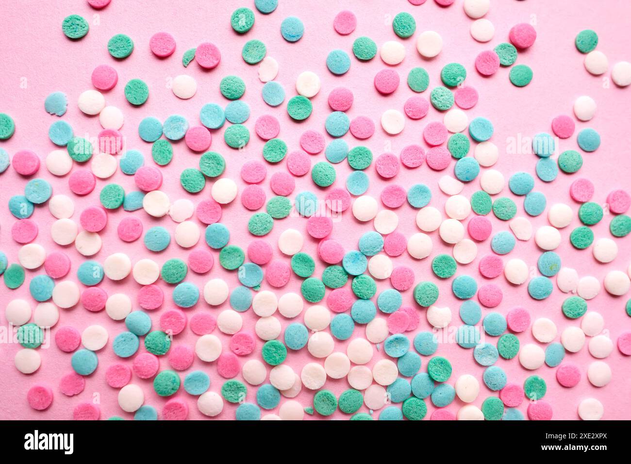 Multi-colored confectionery topping on a pink. Stock Photo