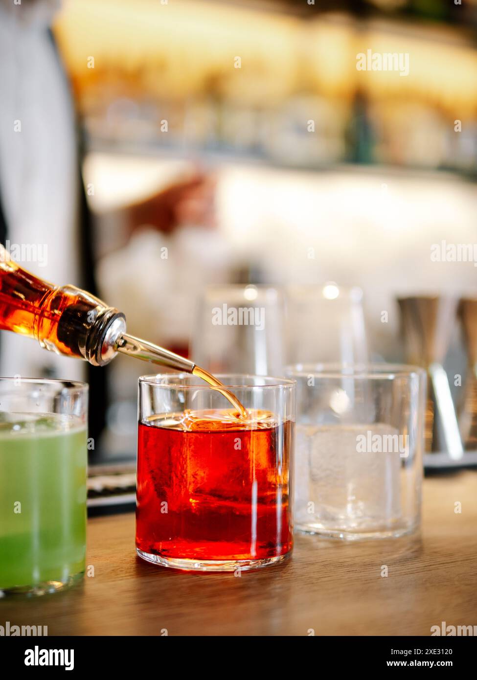 Bartender making Negroni cocktail on bar counter Stock Photo