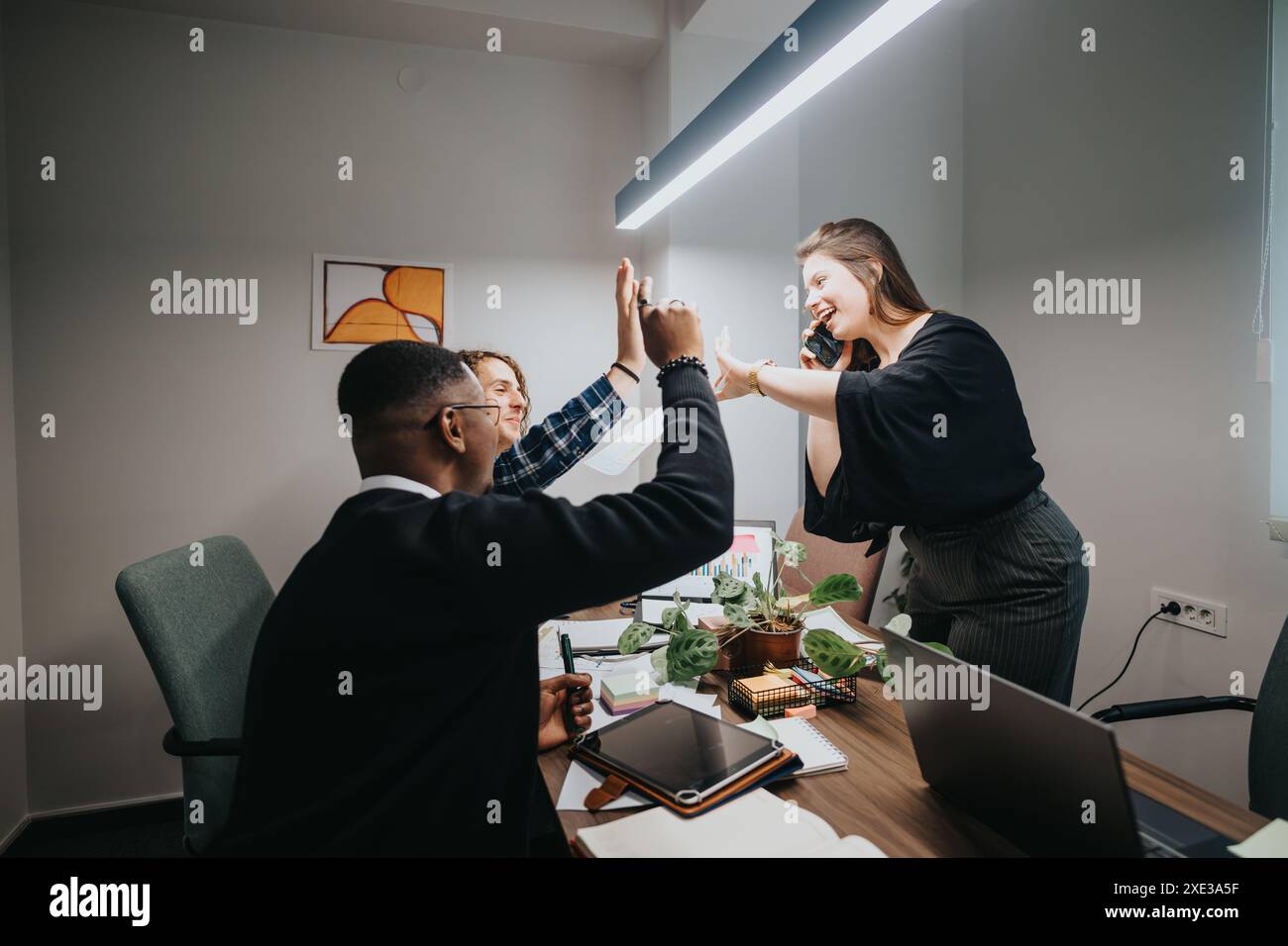 Diverse office team celebrating success with a high five in a modern ...