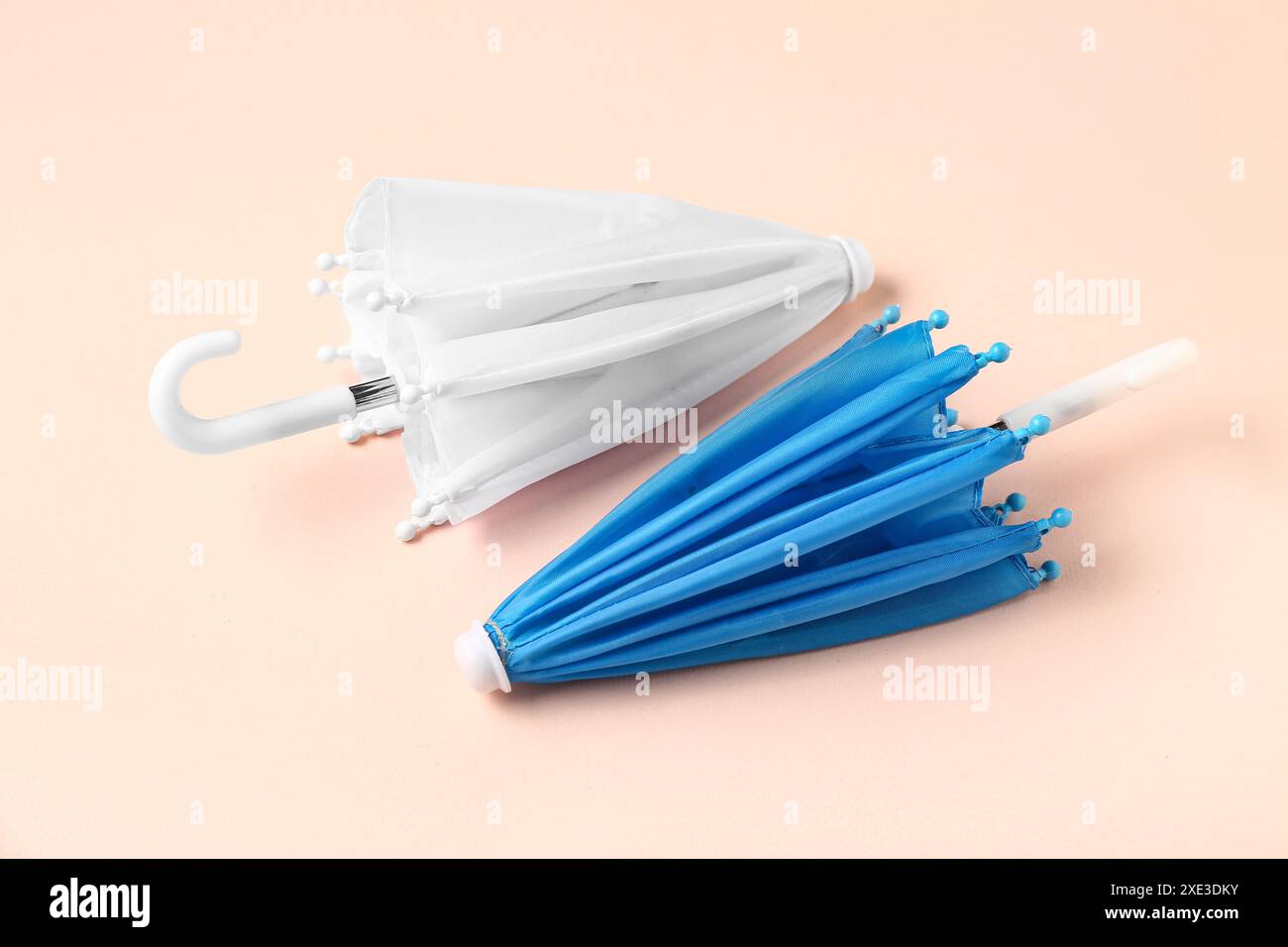 Mini stylish umbrellas on beige background Stock Photo