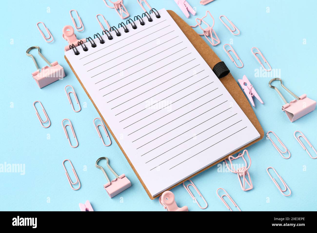Office notebook and different paper clips on blue background Stock ...