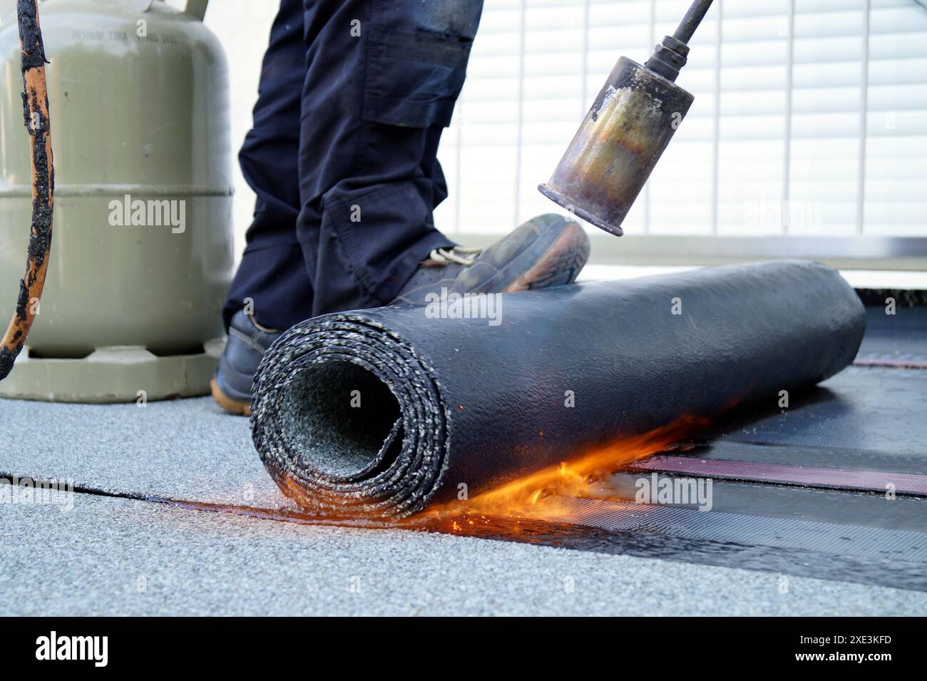 Flat Roof Installation With Propane Blowtorch During Construction Works