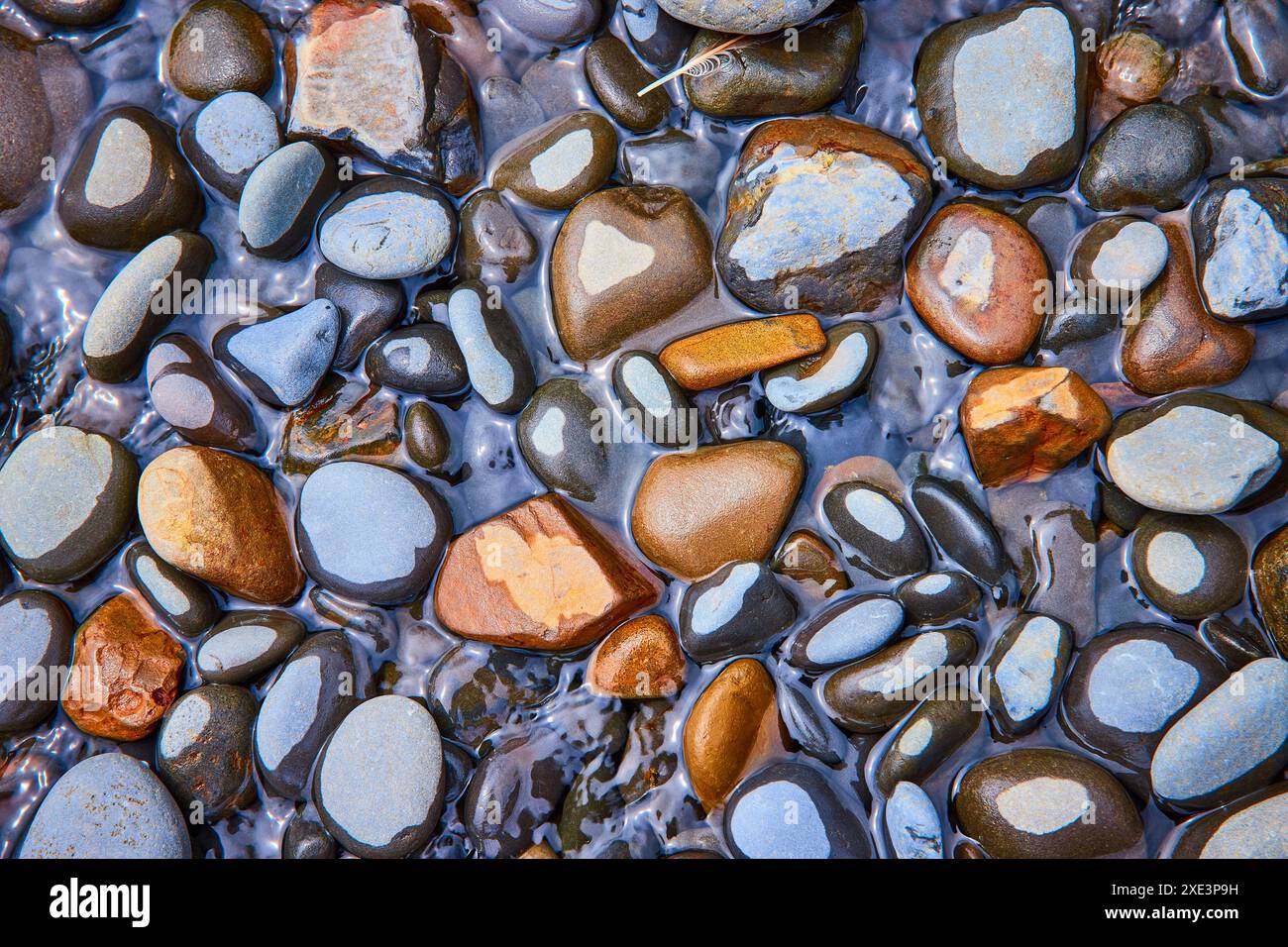 Smooth Stones in Rippling Water Top-Down View Stock Photo