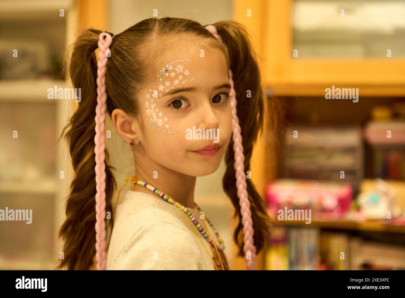 Side portrait of a beautiful girl with white stars painted on her face ...