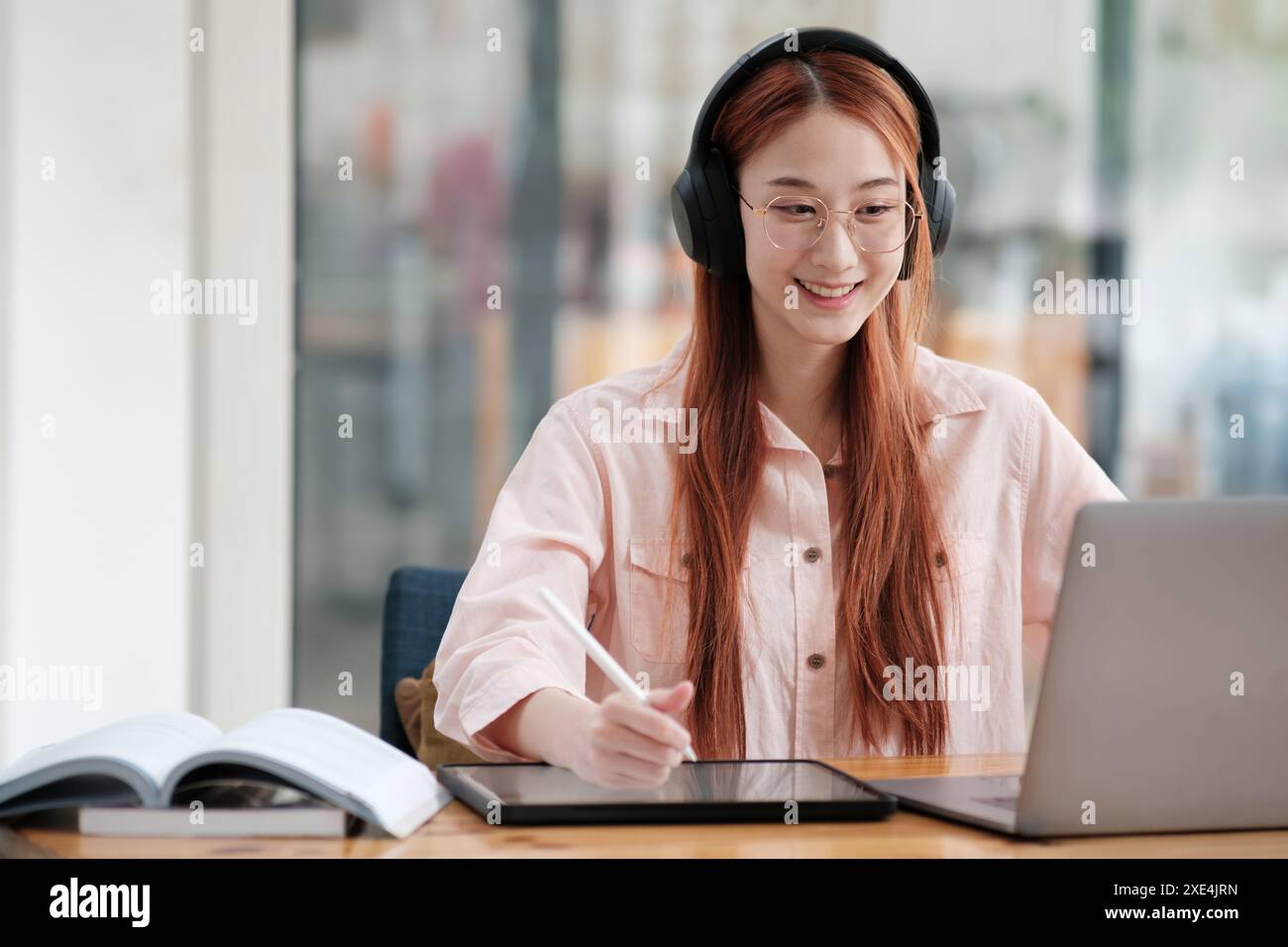 Young collage student using computer and mobile device studying online. Stock Photo