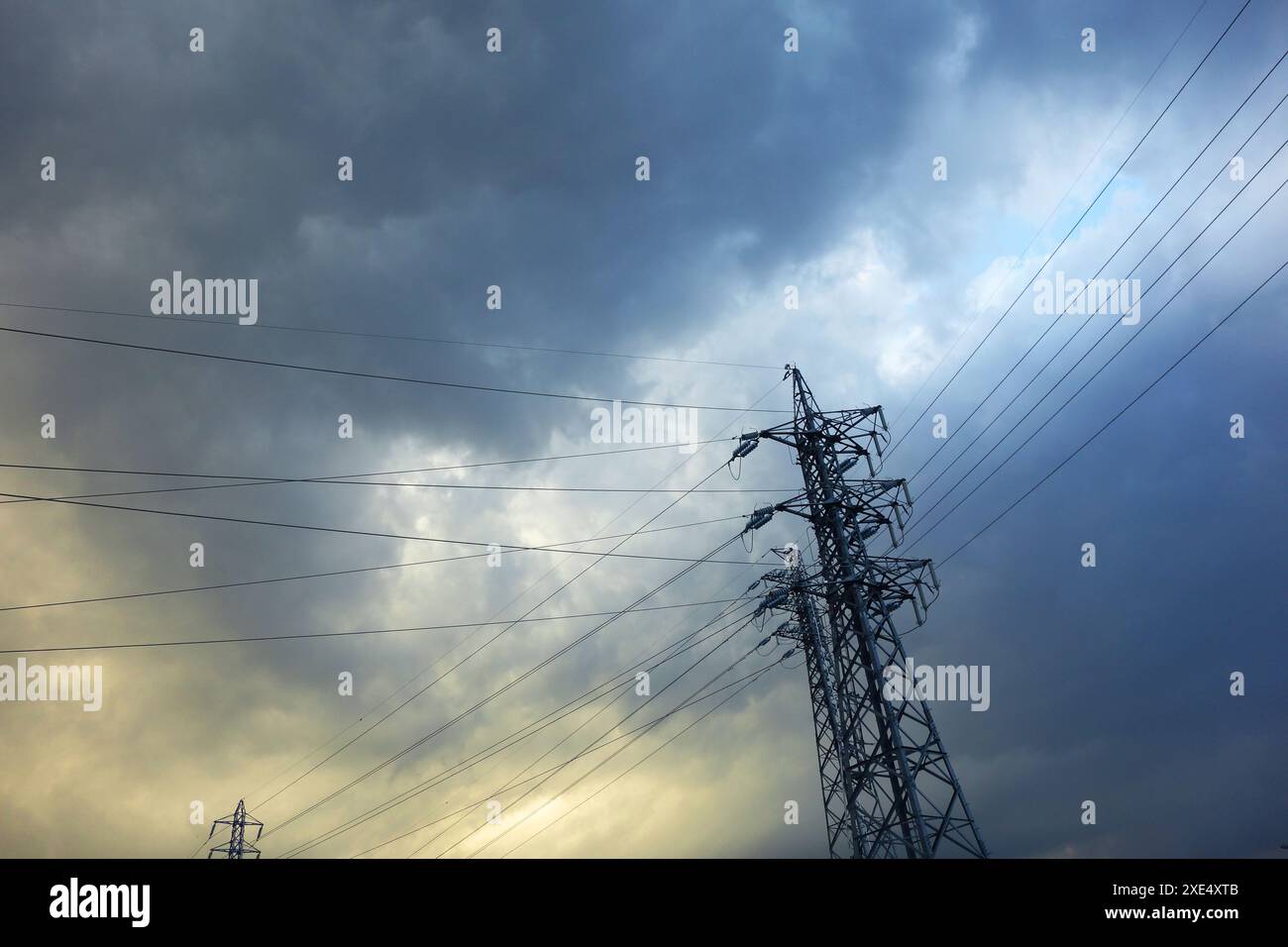 High-voltage power lines and cloudy sky Stock Photo - Alamy