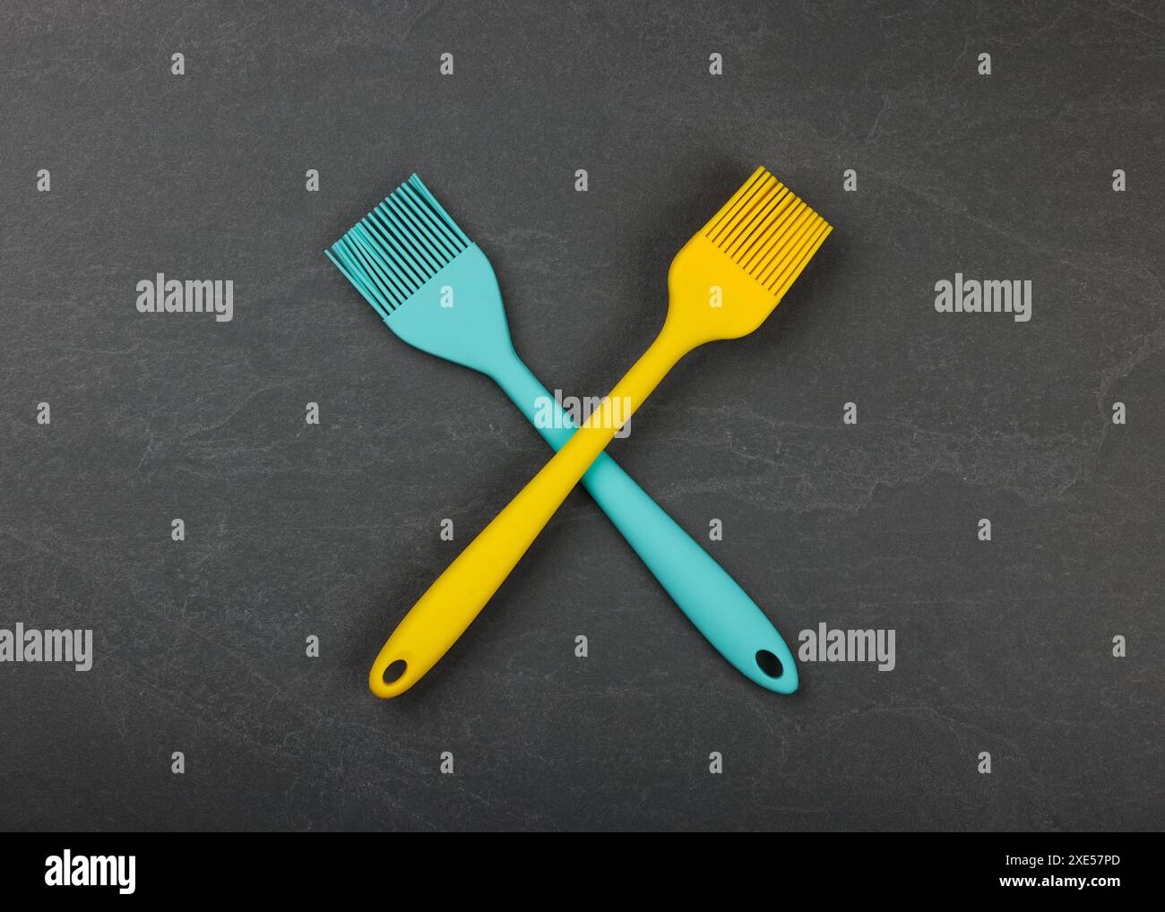 Two silicone culinary brushes on black slate board Stock Photo
