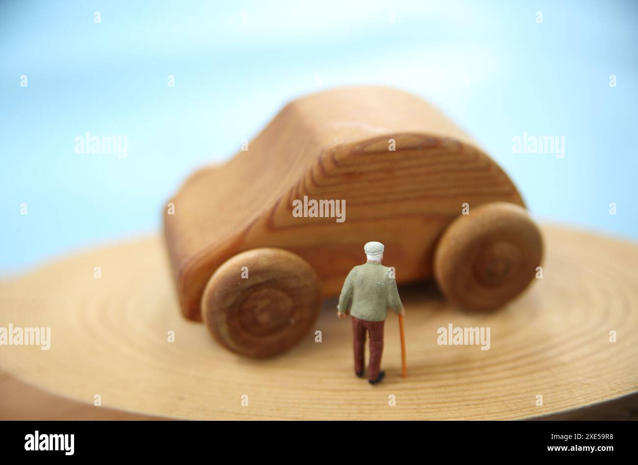 Miniature old man and wooden car Stock Photo