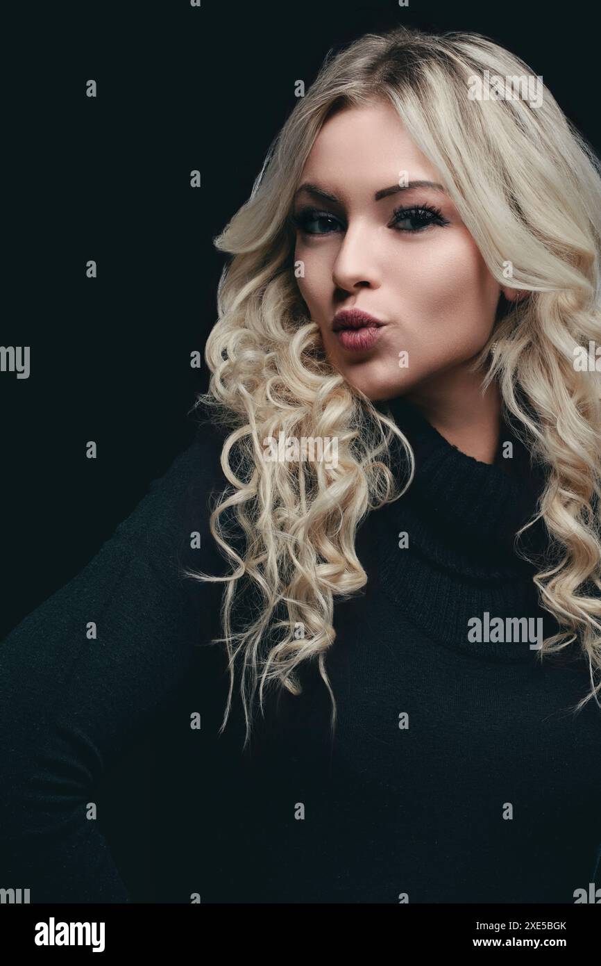 Blonde woman with curly hair and black turtleneck sweater, posing with