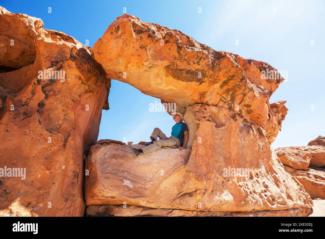 Tourist on a bizarre sandstone cliff in Bolivia Stock Photo - Alamy
