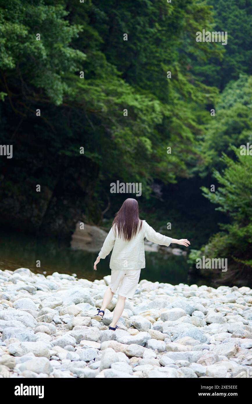 Back view of Japanese woman walking along riverbank Stock Photo - Alamy