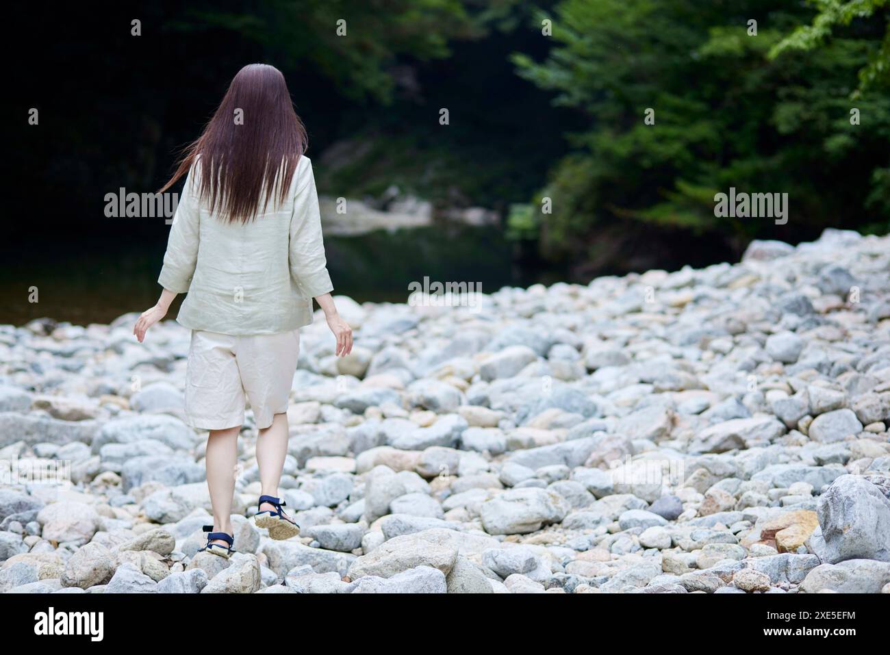 Back view of Japanese woman walking along riverbank Stock Photo - Alamy