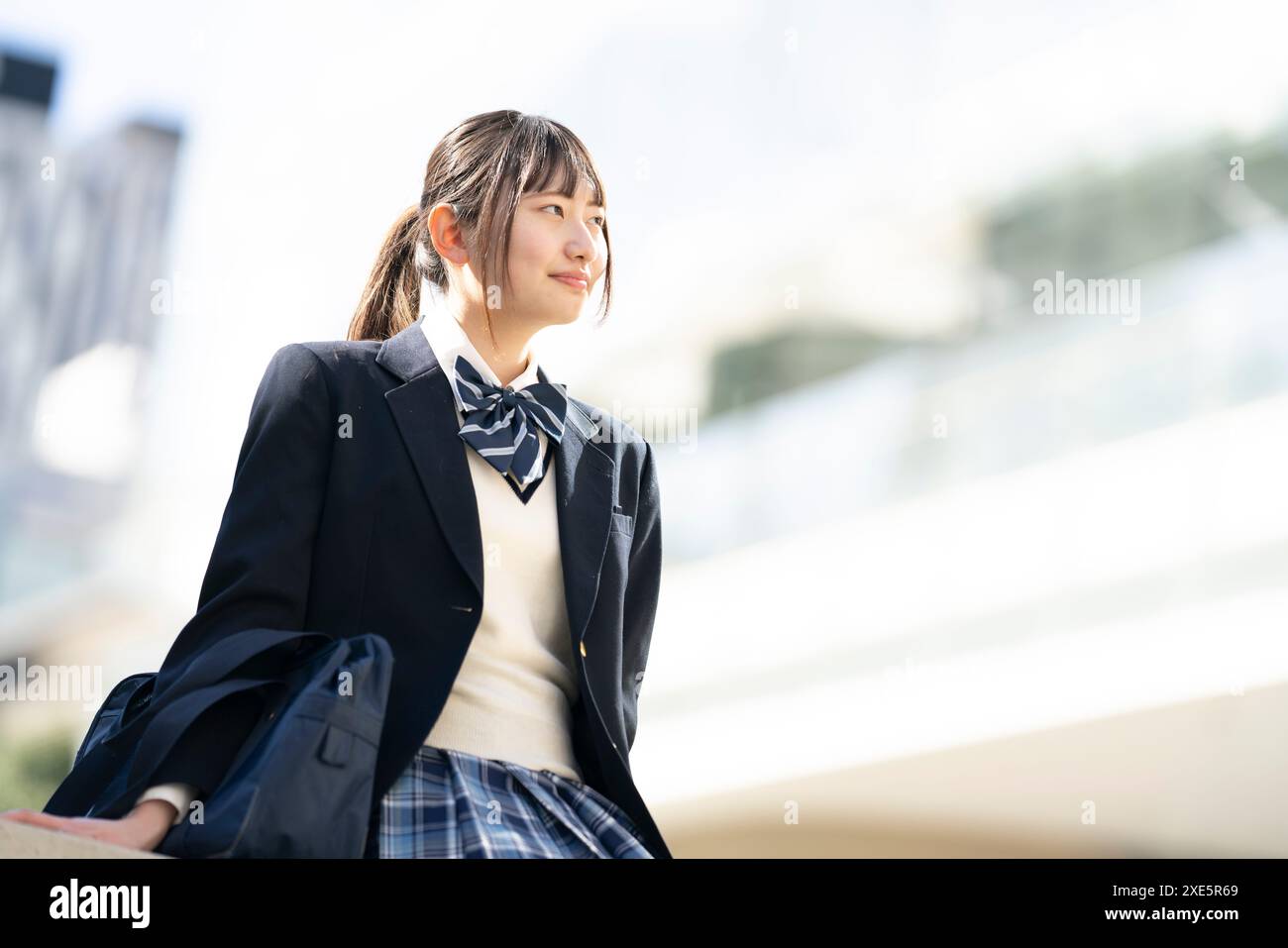 High school girl in uniform sitting outdoors Stock Photo - Alamy