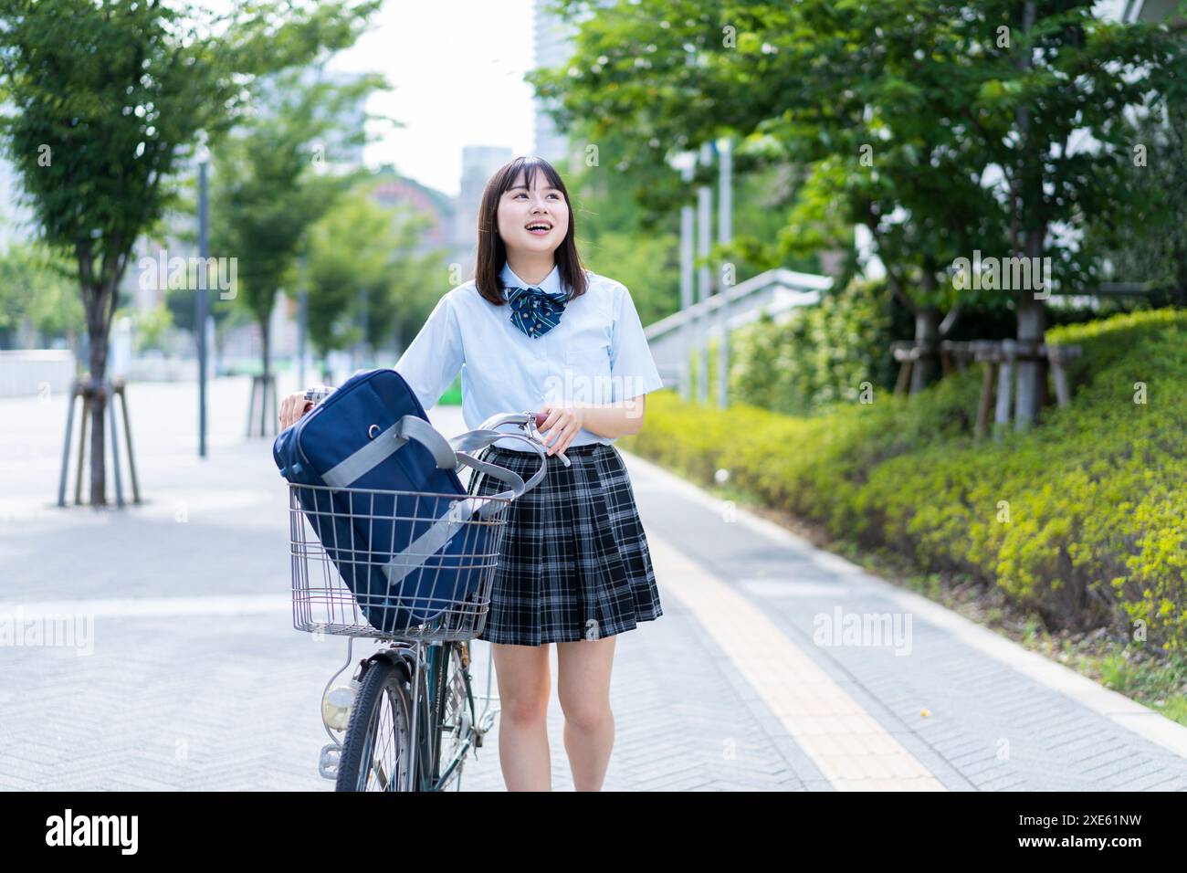 Girl pushing bicycle Stock Photo - Alamy