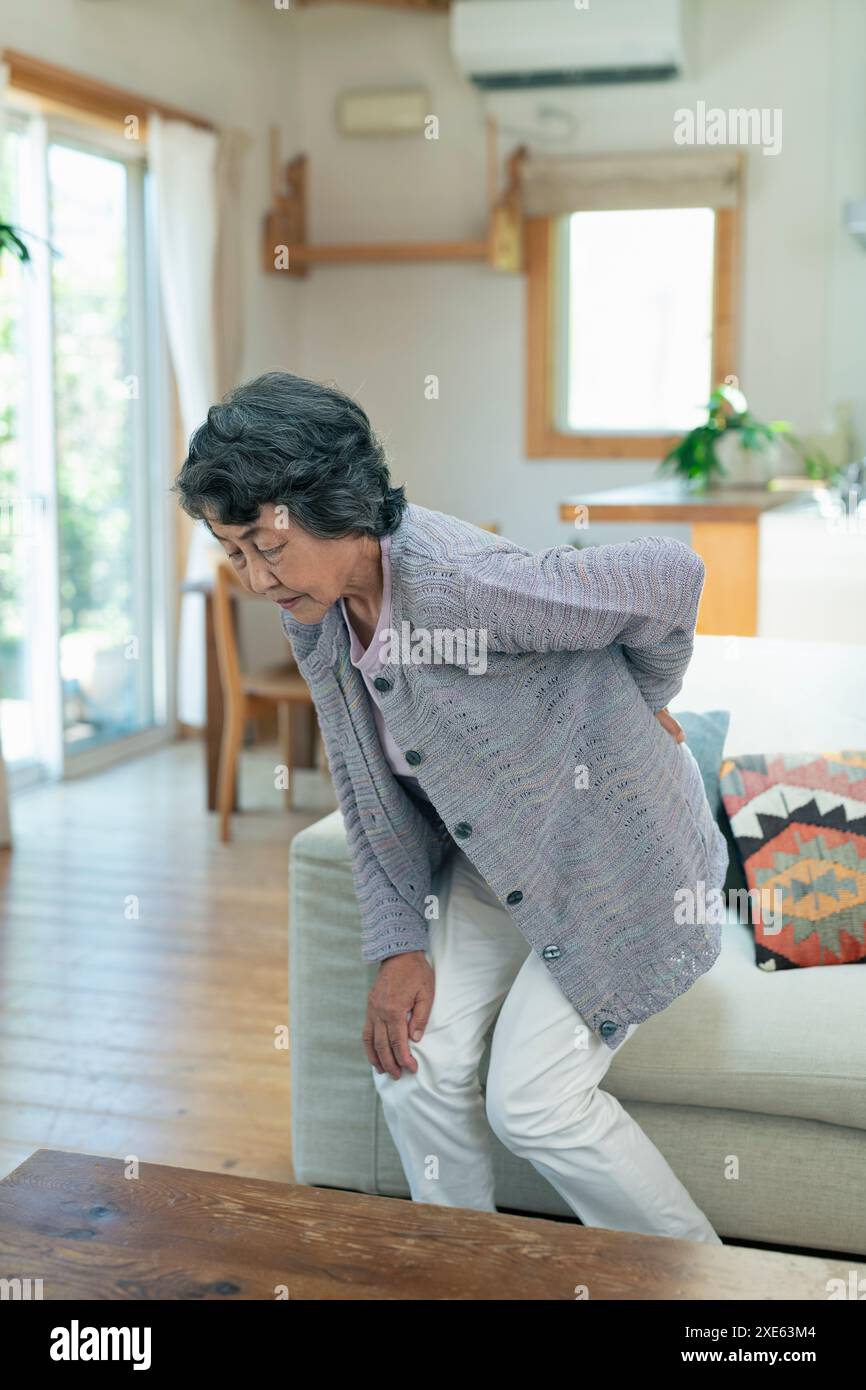 Senior woman suffering from back pain Stock Photo - Alamy