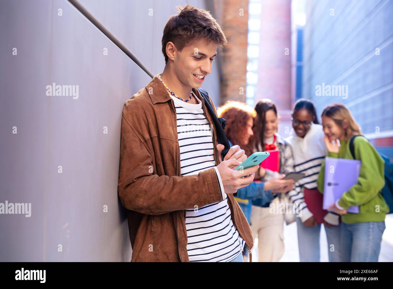 Young caucasian man browsing the internet using smartphone outdoors. Stock Photo