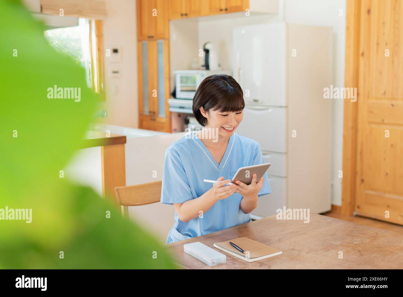 Female healthcare worker writing a journal on a tablet Stock Photo