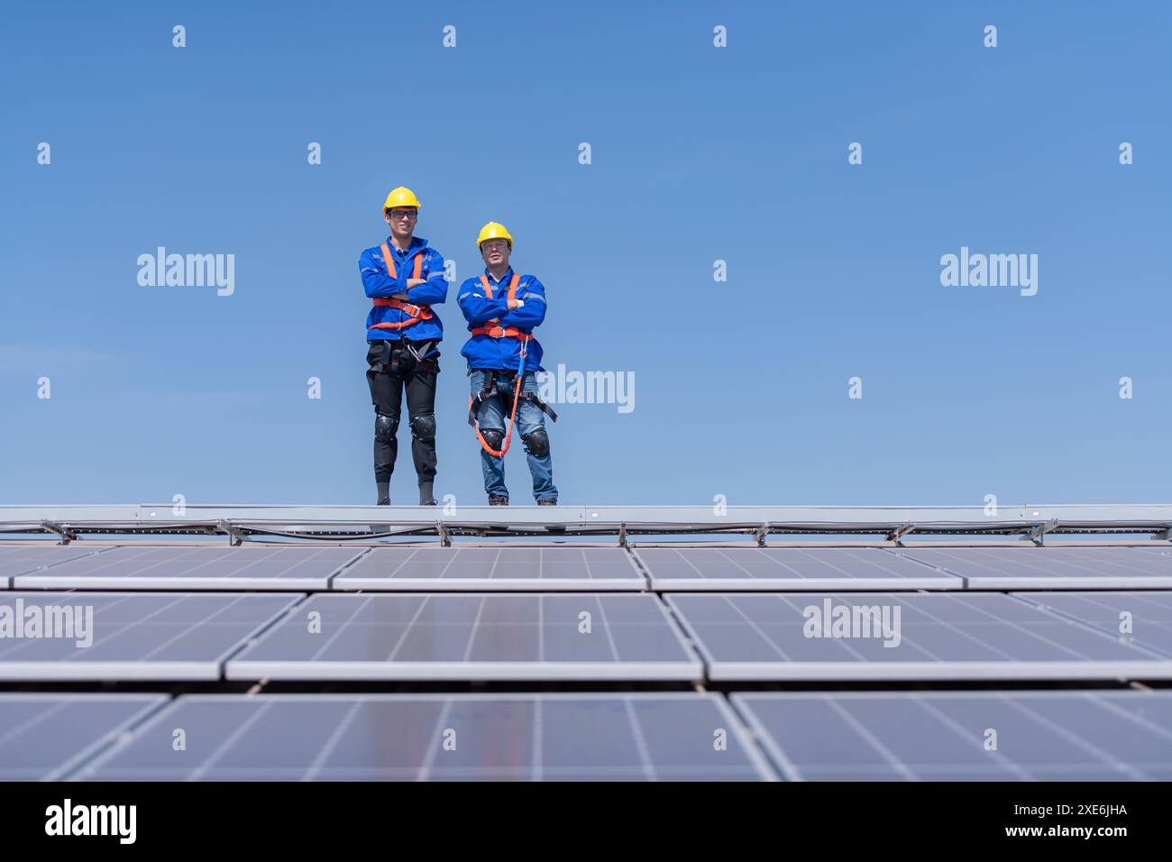 Portrait of two engineers working on a photovoltaic solar panels, Standing with their arms crossed Stock Photo