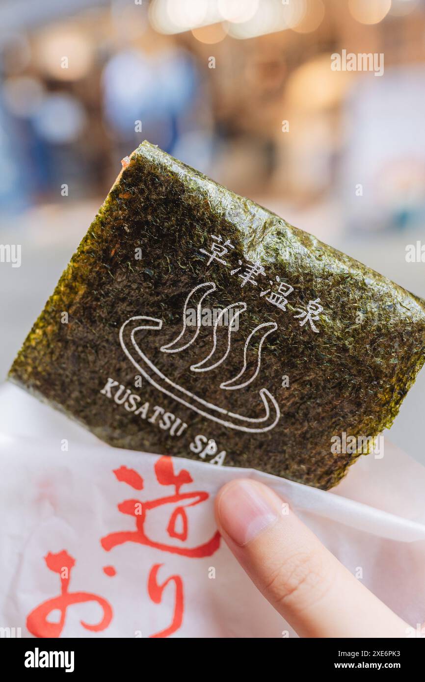 Eating rice crackers in Kusatsu Onsen Stock Photo