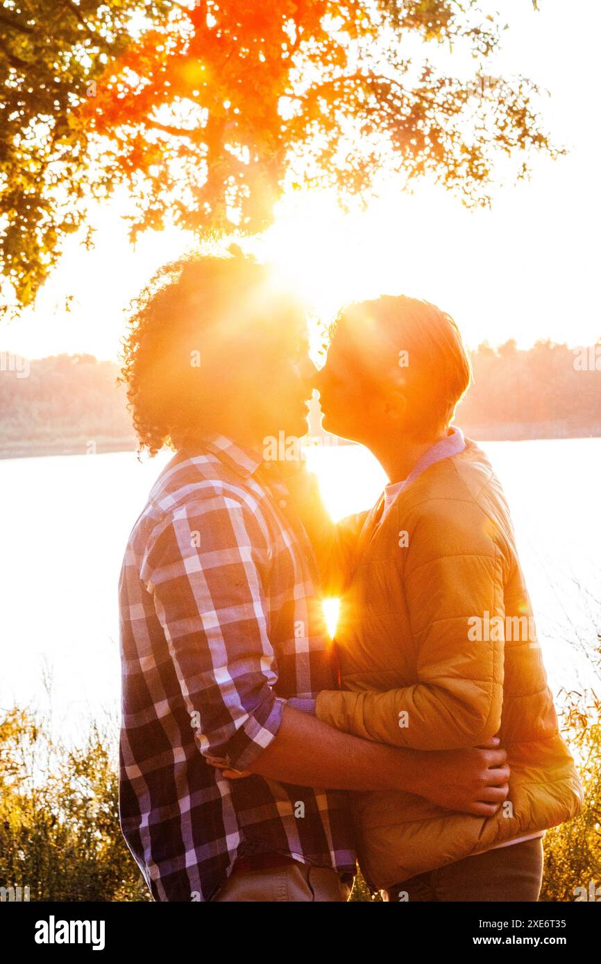 Romantic Kiss at Sunset by the Lake Stock Photo