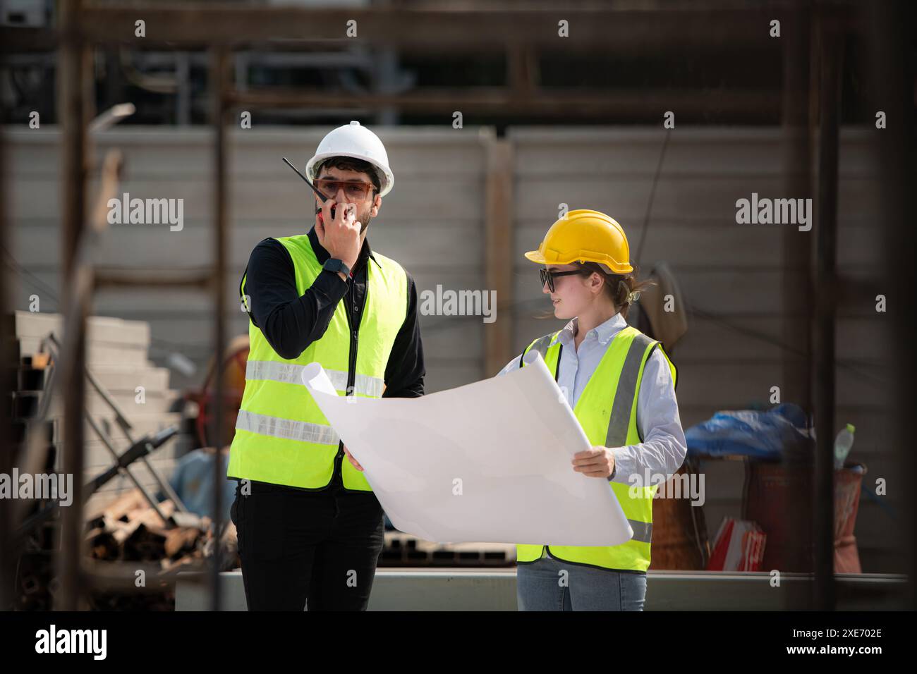 Engineer and architect working on the construction site, double-checking plans and process. Stock Photo