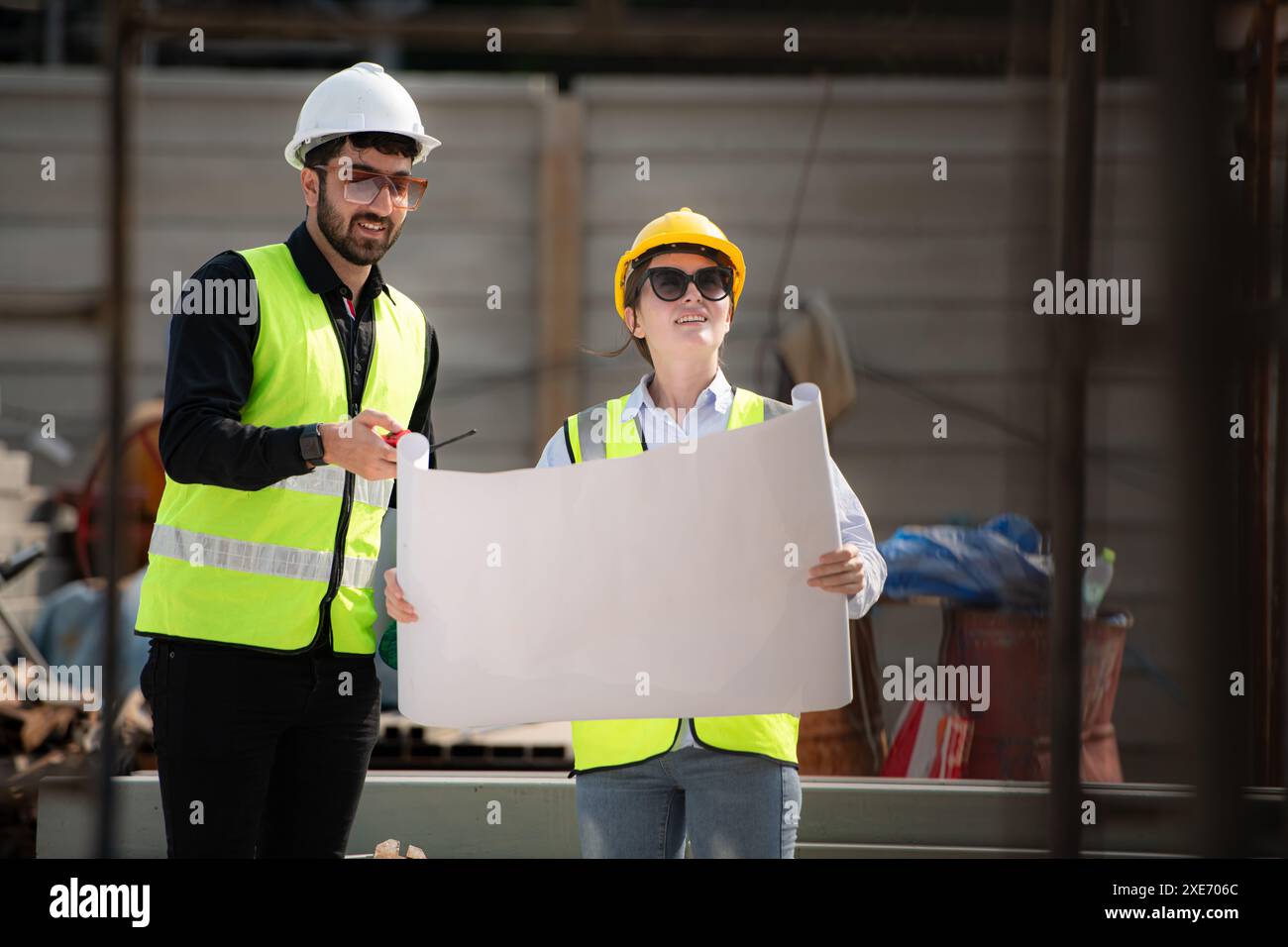 Engineer and architect working on the construction site, double-checking plans and process. Stock Photo