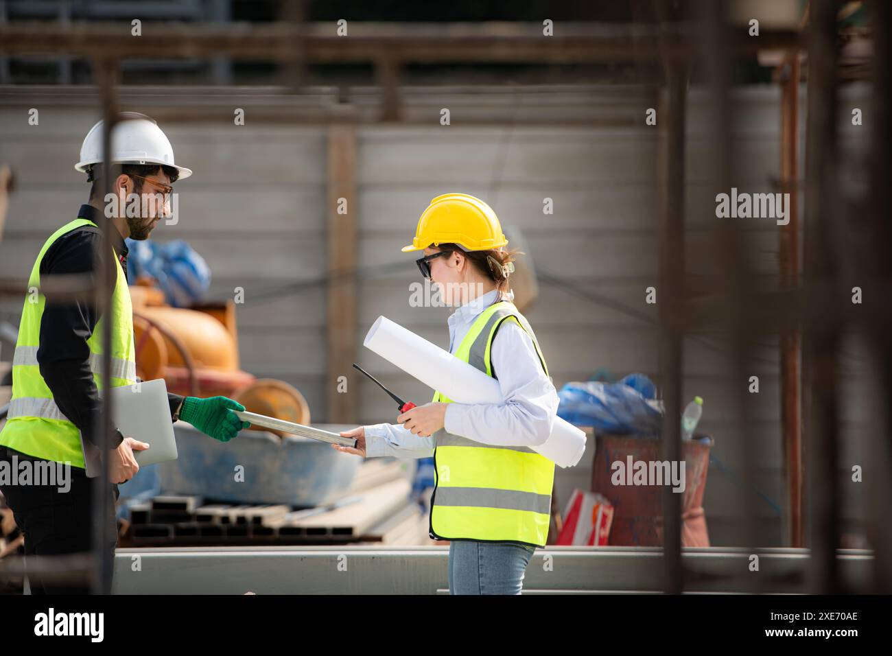 Engineer and architect working on the construction site, double-checking plans and process. Stock Photo