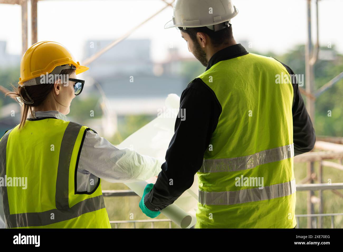Engineer and architect working on the construction site, double-checking plans and process. Stock Photo