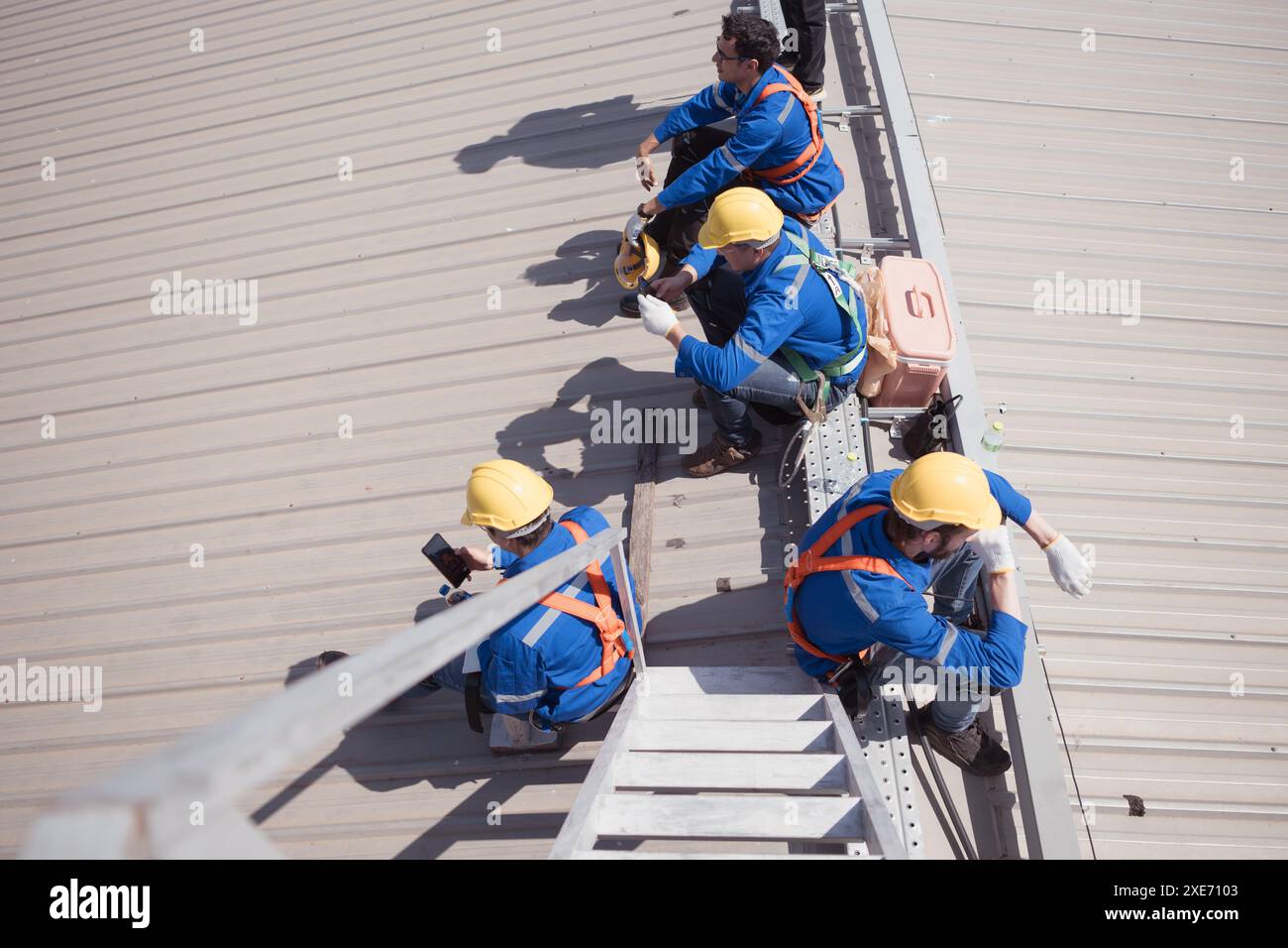 Workers on a construction site take a break on the roof of a building. Stock Photo