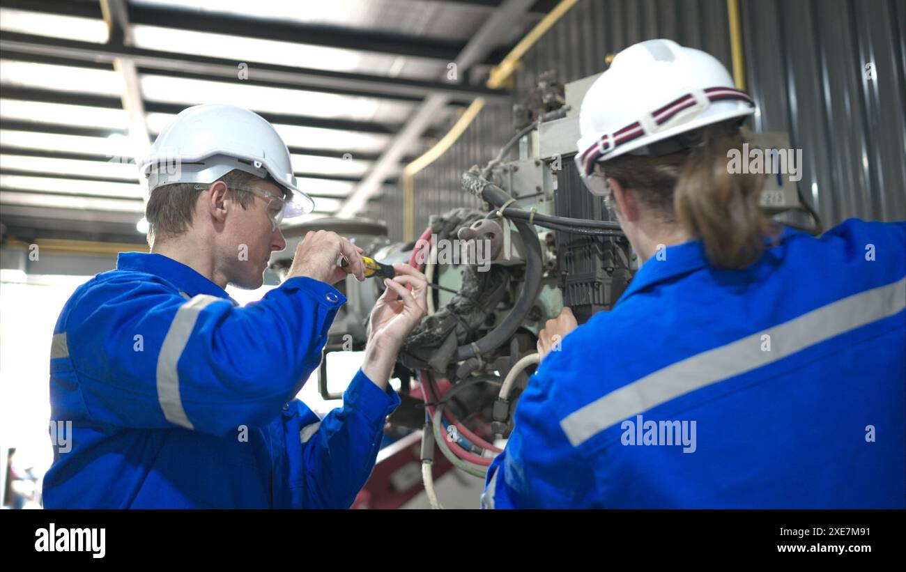 Both of engineers working together in a robotic arm factory, Robotic arm industry and engineering concept. Stock Photo