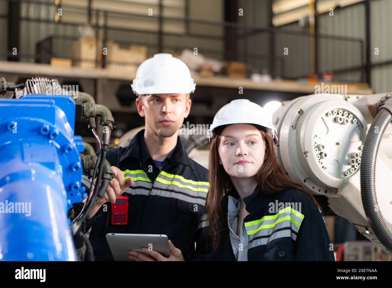 Both of engineers working together in a robotic arm factory, Robotic arm industry and engineering concept. Stock Photo