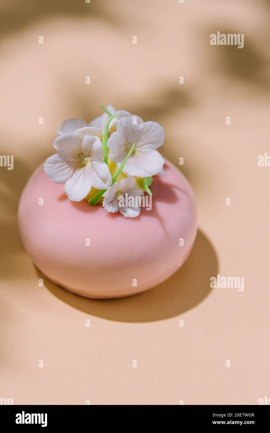 Pink mousse cake with mirror glaze decorated with flowers Stock Photo