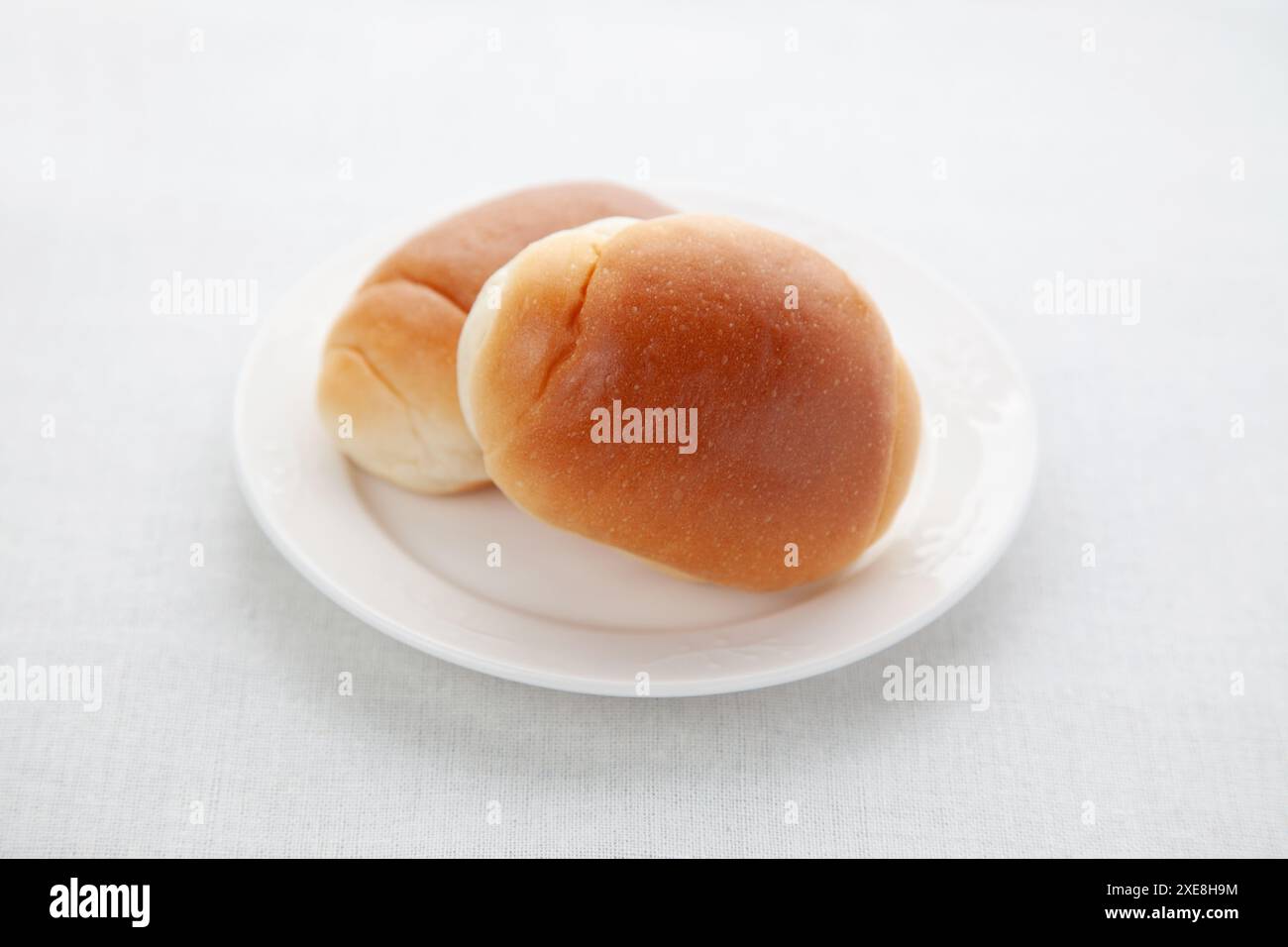 butter bread table rolls on plate isolated on table Stock Photo